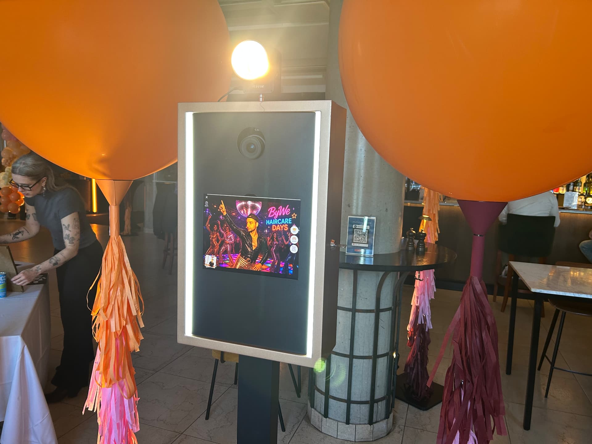 AI-porträtt på det Lyxiga fotobåsets skärm med ByWe-branding och ballonger